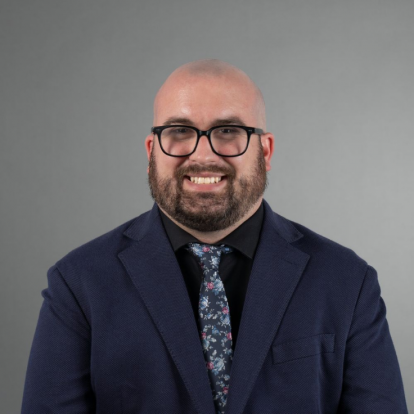 Ethan Williamson smiling wearing blue suit jacket with floral tie