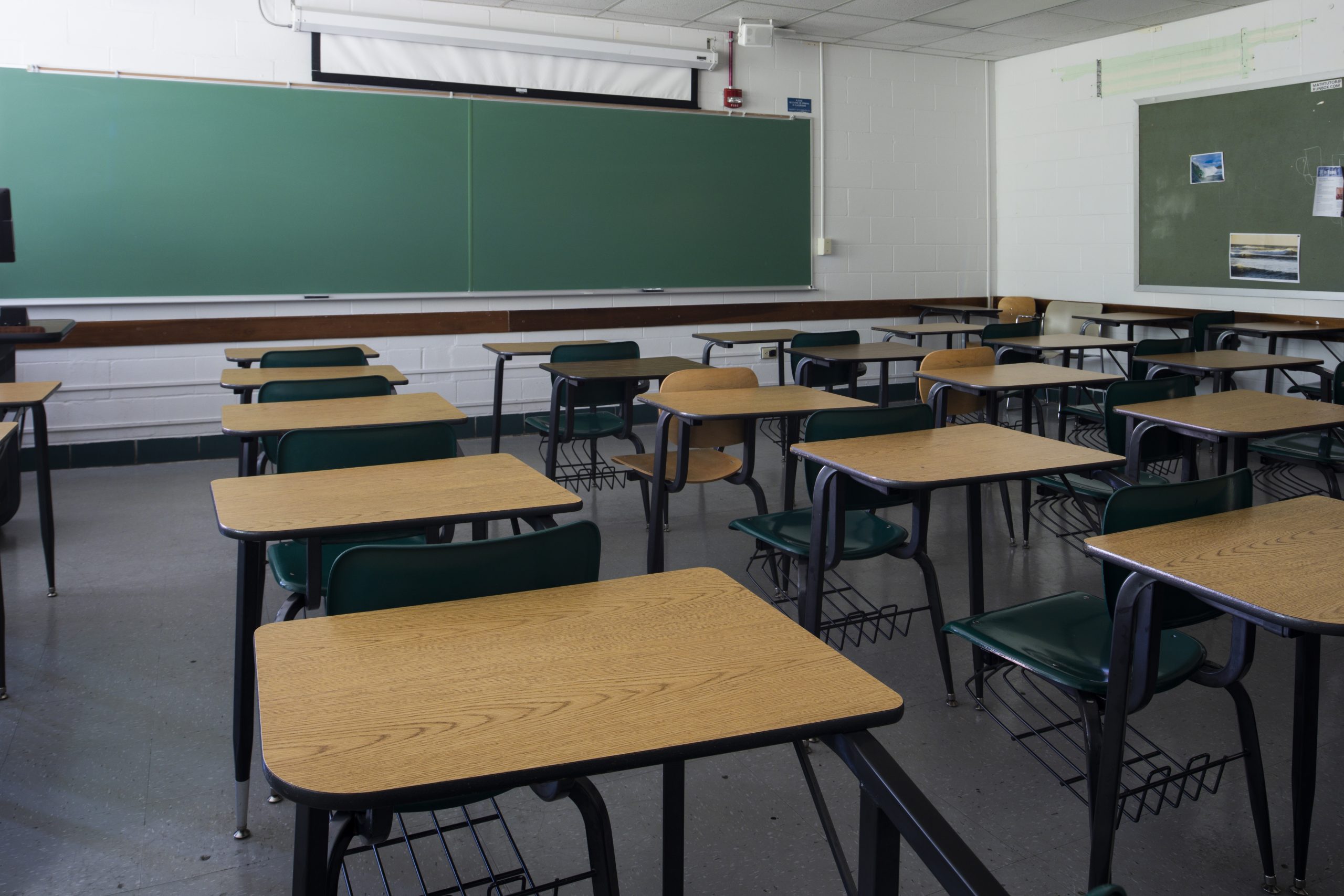 Desks and an empty classroom with a chalkboard in McCarty Hall